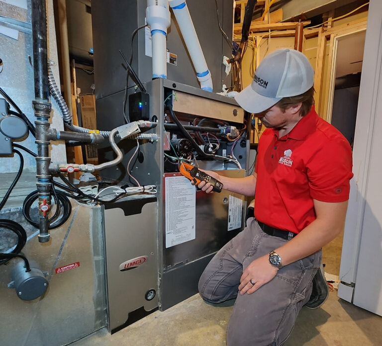 Bison Home Service HVAC Technician Repairing a Furnace